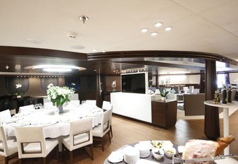 circular dining table forms the indoor dining area on board motor yacht KATINA 