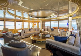 large seating area surrounding by windows on board luxury yacht Excellence V