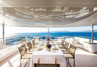 alfresco dining setup on the upper deck aft of motor yacht VICTORY