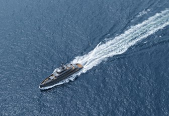 Aerial image of motor yacht ERICA.  Her impressive grey exterior is central with a stream flowing behind