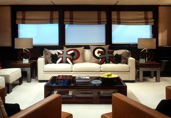 Comfortable interior of Illusion I yacht with windows behind and comfortable sofa