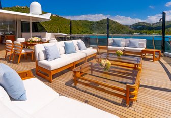 Charter yacht SCOTT FREE exterior seating with white sofas and glass windows