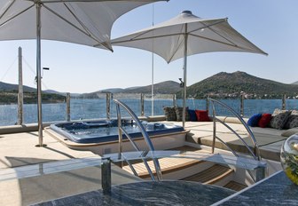 spa pool surrounded by sun pads and umbrellas on the sundeck of luxury yacht Mary-Jean II 