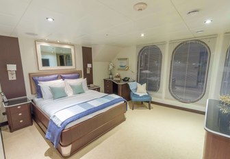 master suite with huge port hole windows on board charter yacht GLOBAL 