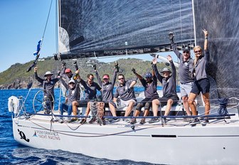 sailors competing at Les Voiles de Saint Barth celebrate as the cross the finish line