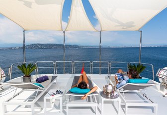 charter guests relax on the sun loungers aboard motor yacht DXB 