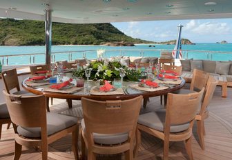 circular alfresco dining table on the upper deck aft of luxury yacht IMPROMPTU 