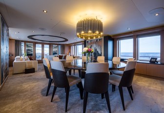 circular table under striking light fixture forms formal dining setup on board charter yacht GO