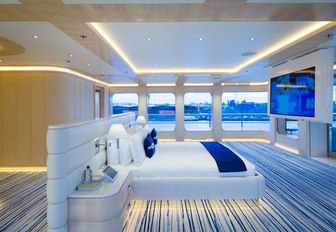 the bright and airy master stateroom in charter yacht aquarius with blue and golden accents throughout 