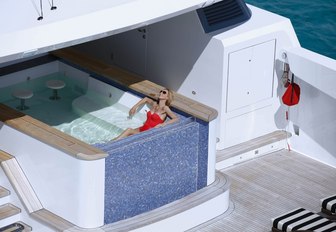 charter guest relaxes in pool aboard charter yacht SOVEREIGN 