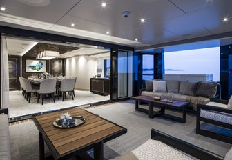 winter garden with comfortable sofas leads into a dining salon on board motor yacht Irisha