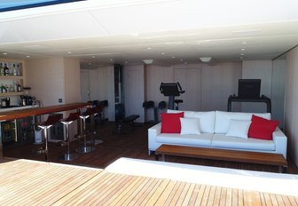 wet bar, sofa and gym equipment in the beach club aboard superyacht G3