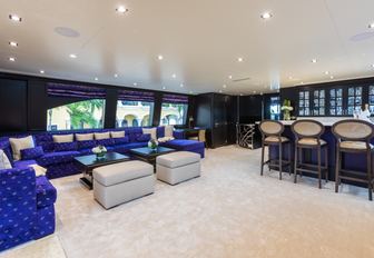 Superyacht charter TANZANITE interiors with blue sofa and wet bar