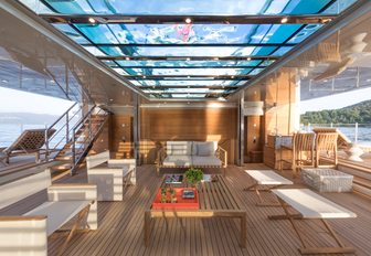 light filters through a pool above into the chic beach club aboard charter yacht Seven Sins