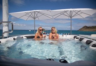 charter guests relax with a cocktail in the spa pool on board motor yacht TRENDING 