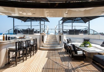 bar and seating area with steps up to pool on sundeck of luxury yacht Silver Angel