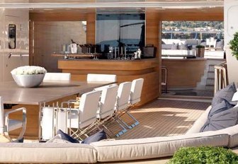 luxury yacht sundeck with dining, bar and selection of plants