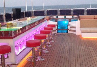 bar and Jacuzzi on the sundeck of superyacht Code 8 light up as the sun begins to set