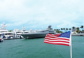 An American flat in front of a superyacht berthed in Miami