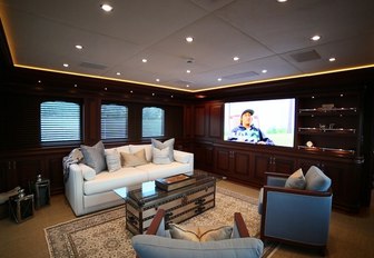 the classically styled upper loung with flat screen tv, bookshelf and luxurious seating inside charter yacht clarit