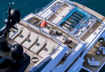 the three aft decks of charter yacht lady lena with sun loungers, glass bottom infinity pool, and platform side decks