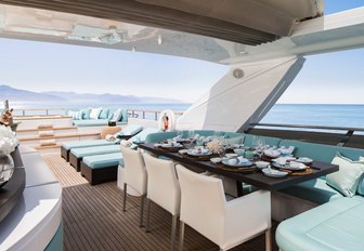 table is set for dinner under the retractable sunroof on the sundeck aboard luxury yacht CRISTOBAL 