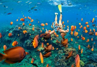 a luxury yacht charter guest scuba diving during her vacation in the bahamas