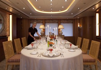 crew member sets dining table for a formal occasion aboard charter yacht OASIS