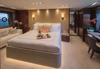 the airy and welcoming vip stateroom of charter yacht hot pursuit with side desk and window looking out into the caribbean