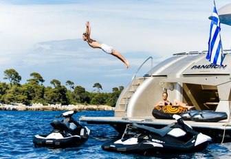 male charter guest dives of swim platform aboard luxury yacht PANDION as female guest watches