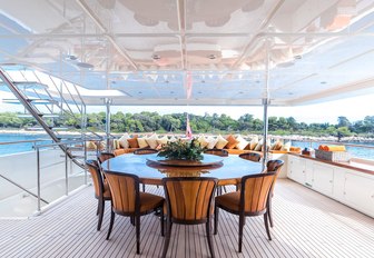 circular alfresco dining table on the upper deck aft of charter yacht Avant Garde 2