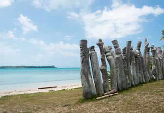 Old wooden guardians on the beach of the Saint Maurice Bay on the Pines Island in New Caledonia