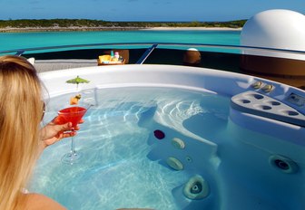 jacuzzi on superyacht with charter guest enjoying cocktail