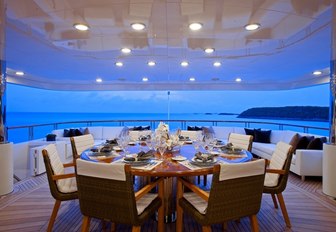 large alfresco dining area at night on upper deck aft of superyacht COCKTAILS 