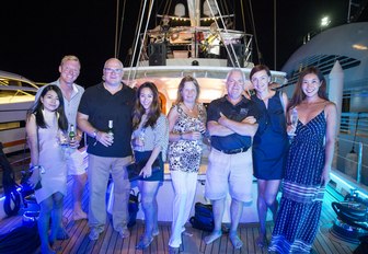 attendees pose on the deck of a yacht at night at the Thailand Yacht Show & Rendezvous 