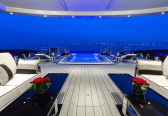 alfresco lounge looking over pool at night on board superyacht OKTO