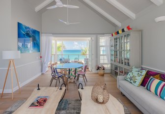 entertainment room on villas of thanda island, with balcony overlooking the sea and sofa in foreground