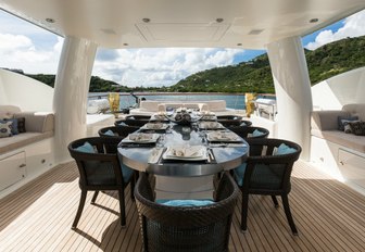 Alfresco dining setup under the shade of the radar arch on the sundeck of motor yacht DENIKI