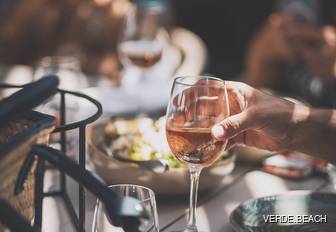 Charter guest holding a glass of wine at Verde Beach