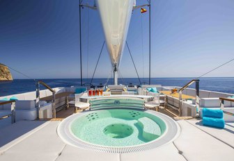 Jacuzzi surrounded by sunpads on the sundeck of luxury yacht AQUIJO