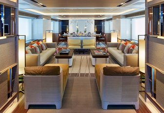 library nook with seating and dining areas beyond in the main salon aboard luxury yacht ASYA 