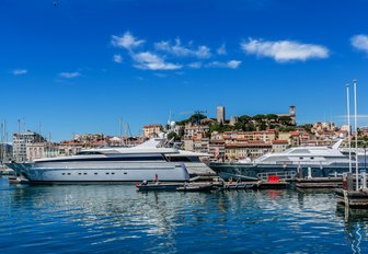 Water-level view of superyacht charters and Le Suquet in the background