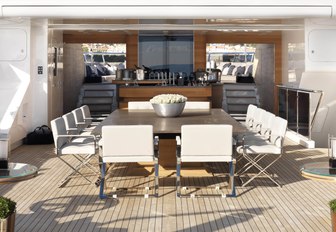 the alfresco dining table and cocktail bar partitioning the fore and aft sundeck of motor yacht SEALYON