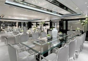 glass-topped table in formal dining area in main salon aboard charter yacht Silver Angel 