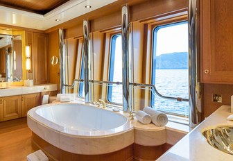 en-suite bathroom with a tub and large windows on board motor yacht BOADICEA 