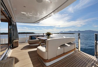 table and chairs on aft deck of superyacht SOLIS with stairs leading to swim platform