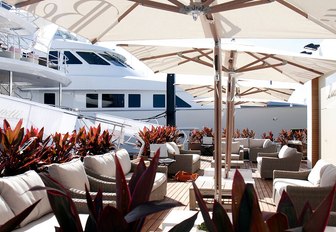 Cafe area with superyacht in background at FLIBS