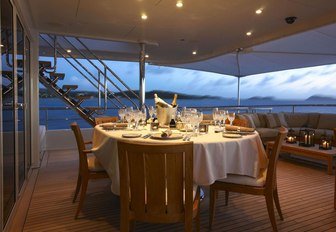 Aft deck alfresco dining at dusk on board superyacht Harle