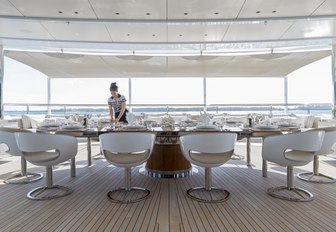 crew member prepares table for dinner on the dining deck aboard charter yacht NAUTILUS 