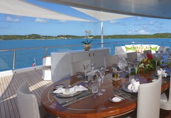 oval table is set for a lunch on the bridge deck aft of luxury yacht AMARYLLIS 